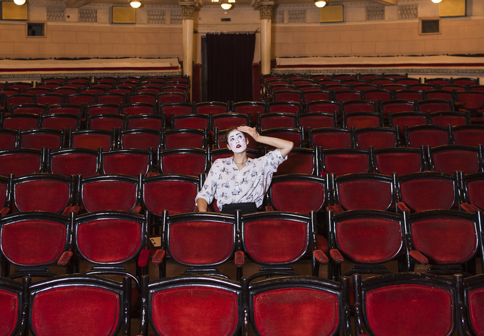 Main sad female mime artist sitting alone auditorium