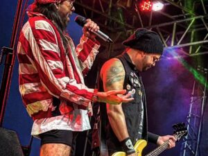 Dois homens cantando rock em um palco