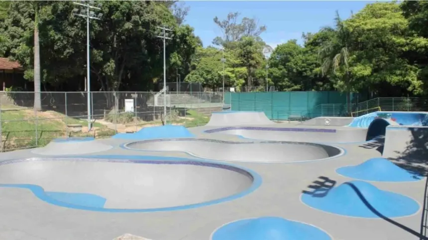Vista ampla da pista de skate do Parque Lagoa do Nado, com bowls, rampas e áreas para manobras, cercada por árvores e alambrados, em Belo Horizonte