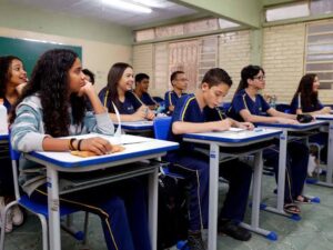 Alunos do ensino médio sentados assistindo aula