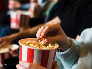 Pessoa comendo pipoca de cinema