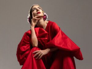 Mulher de vestido vermelho olhando para cima.