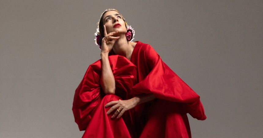 Mulher de vestido vermelho olhando para cima.