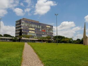 Imagem mostra gramado da UFMG e um prédio.