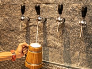 O público se diverte no Oktoberfest Medieval da Forja Taverna com chope, música típica e o tradicional arremesso de machado