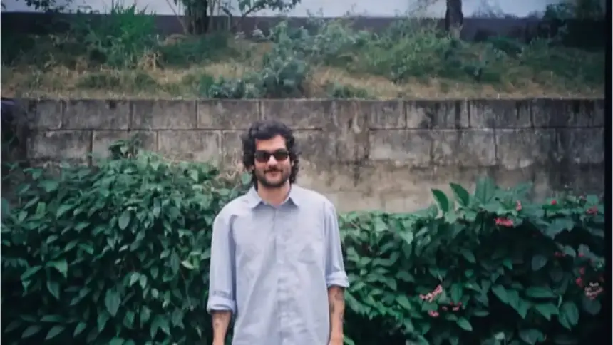 Imagem mostra cantor mineiro João Ferreira com óculos escuros e camiseta azul.