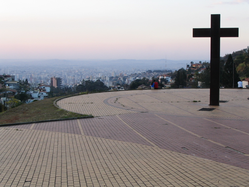 Imagem mostra Praça do Papa durante o dia, caracterizada pela ampla vista da capital e pelo monumento de uma cruz.