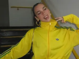 Mulher morena com blusa amarela e verde.