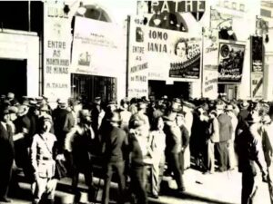 Multidão de pessoas usando trajes formais e chapéus reúne-se em frente ao antigo Cine Pathé, em Belo Horizonte, na primeira metade do século 20.