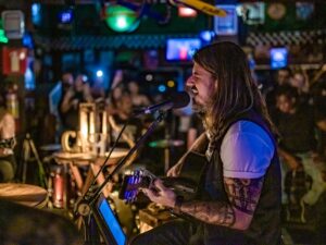 Banda Ca$h durante apresentação registrada por Flavio Charchar; grupo comanda a roda de rock na Festa Rokka no Mercado Distrital do Cruzeiro