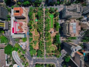 Vista aérea de uma praça arborizada cercada por prédios e avenidas em Belo Horizonte.