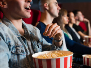 pessoas comendo pipoca em cinema