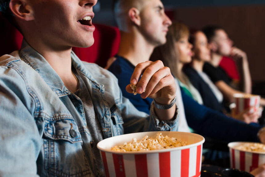 pessoas comendo pipoca em cinema