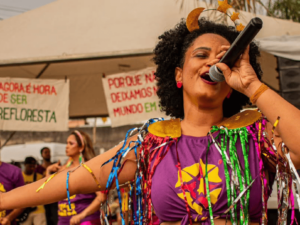 mulher cantando em microfone no Bloco Transborda
