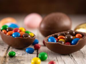 Ovos de Páscoa de chocolate coloridos em mesa de madeira