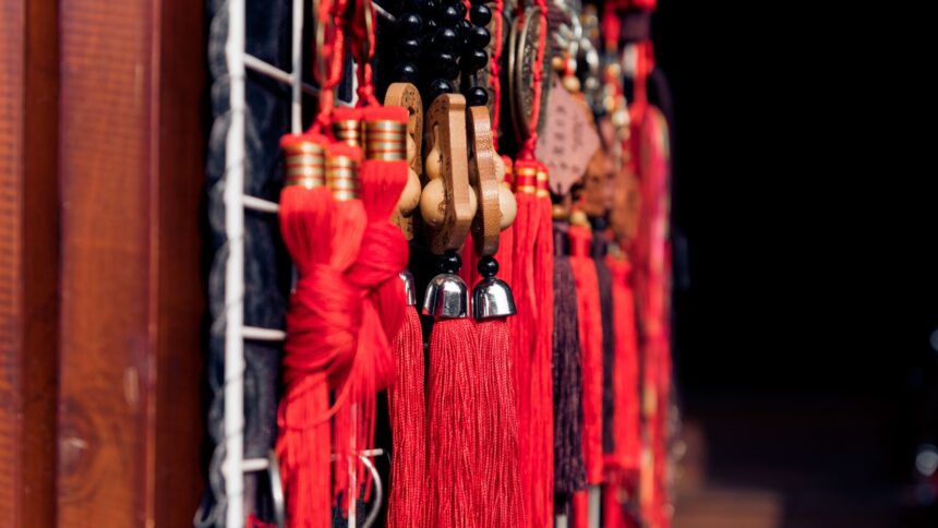 Borlas vermelhas, contas pretas e ornamentos de madeira esculpida, representando a cultura chinesa.