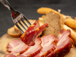 Vista frontal de presunto fresco em fatias com fatias de pão e bolinhos em carne
