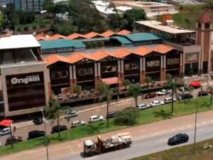 Vista aérea do Mercado de Origem com edifícios, torre do relógio, sinalização e rua movimentada.