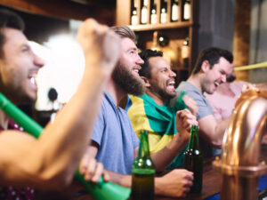 homens felizes assistindo a jogo de futebol