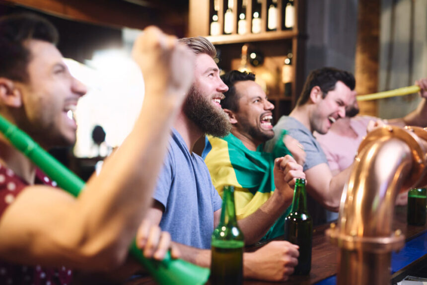 homens felizes assistindo a jogo de futebol