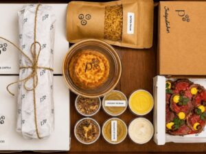 Kit de refeição do Pacato com carpaccio, arroz, batata palha, molhos e tortinhas.