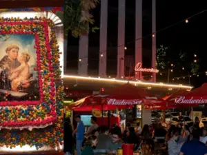 Bolo de Santo Antônio gigante sendo servido em evento no Centro de Belo Horizonte no Dia dos Namorados, com pessoas na fila aguardando as fatias