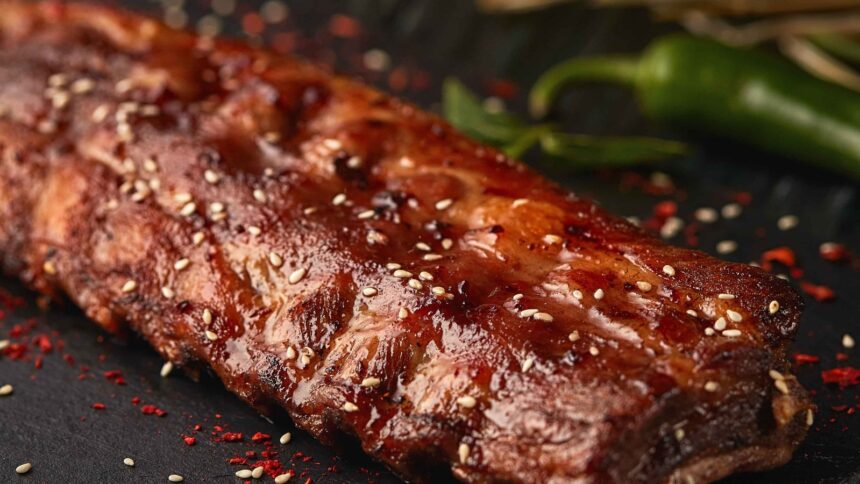 Costela assada com molho brilhante, sementes de gergelim e pimenta vermelha em pó