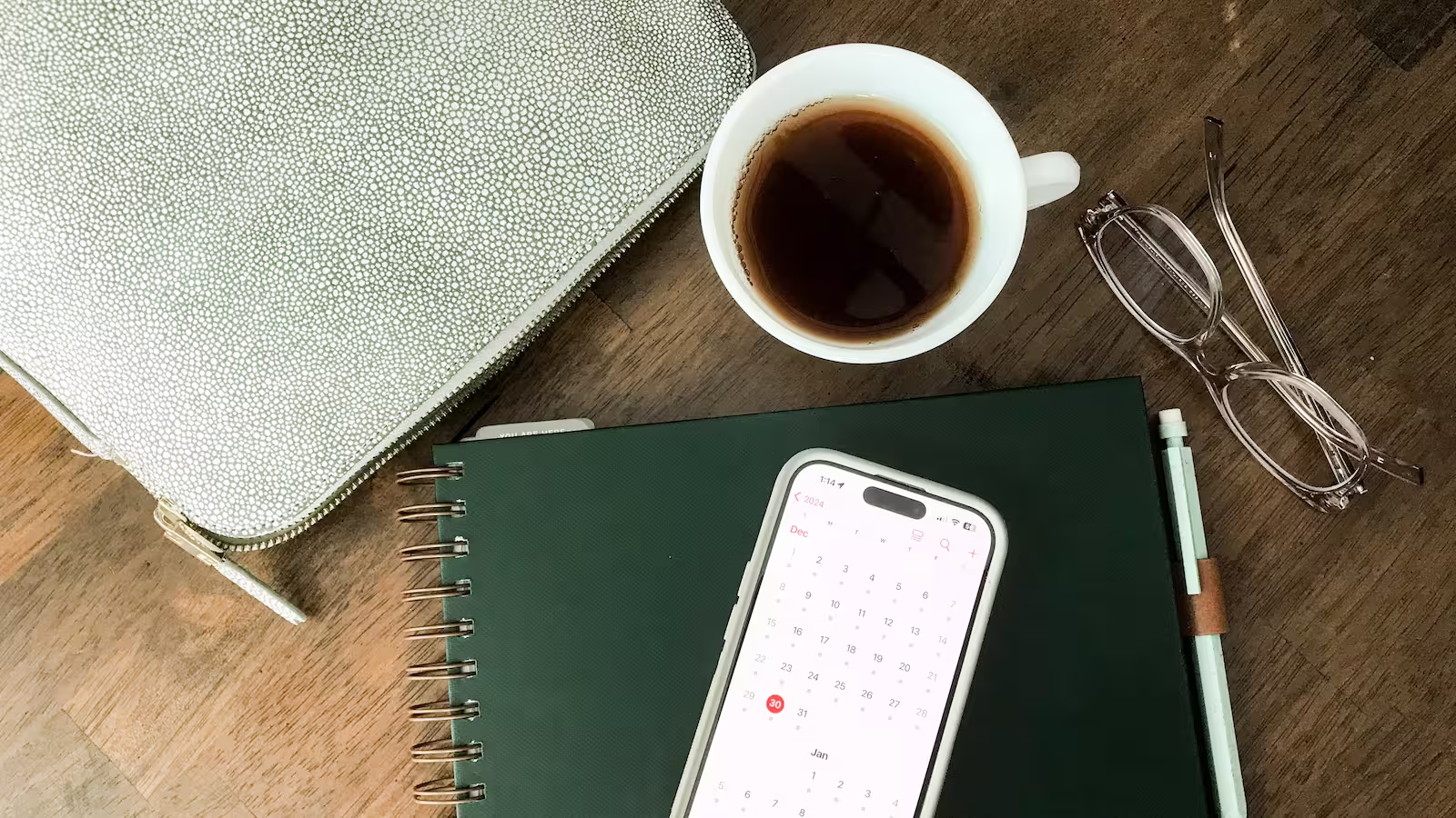 Copo de café, celular, laptop e caderno
