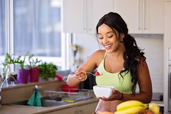 Mulher alegre com camisa verde cozinhando
