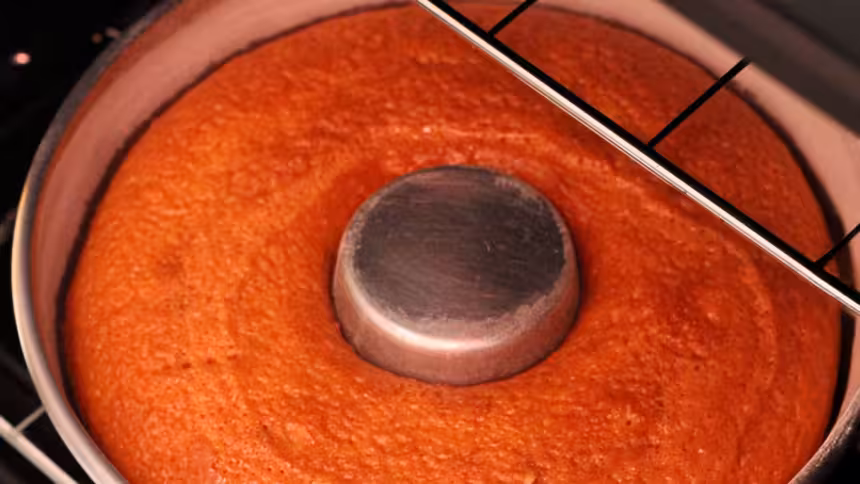 Bolo em forma redonda com tubo central, assando dentro do forno com grade