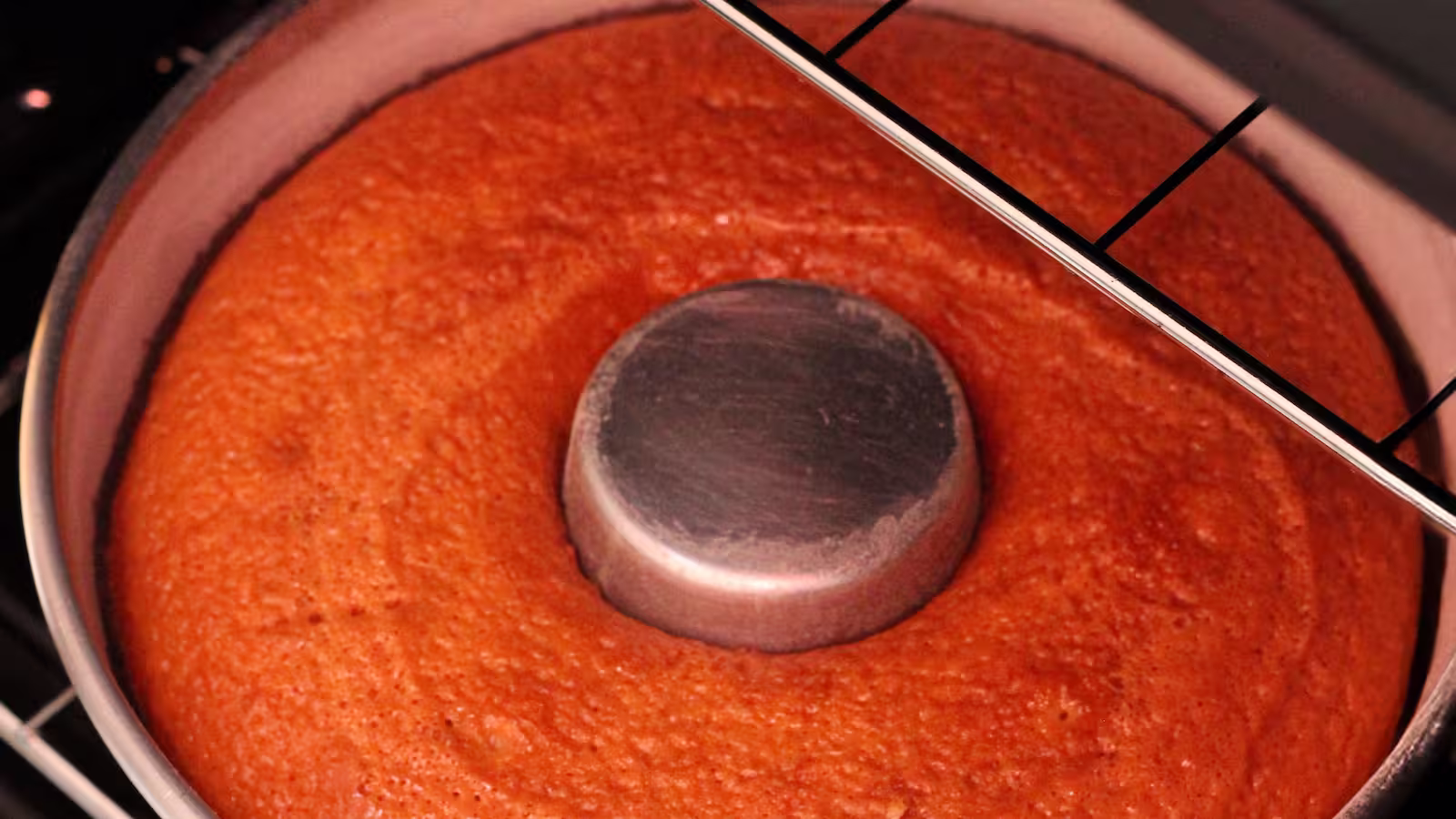 Bolo em forma redonda com tubo central, assando dentro do forno com grade