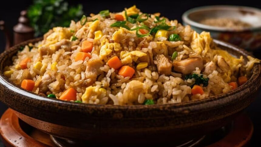 Arroz frito com frango, ovos mexidos, cenoura, milho, ervilhas e cebolinha, servido em tigela