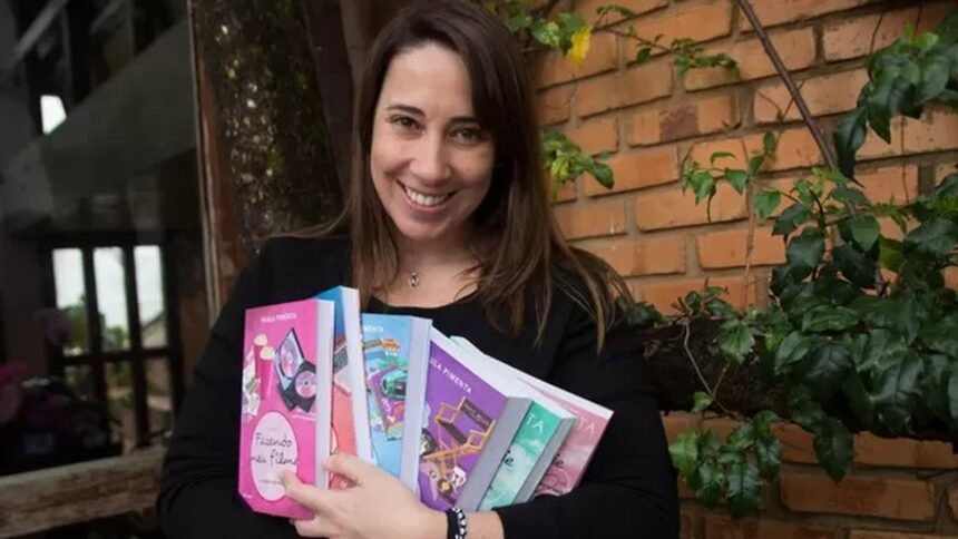 Mulher sorridente de cabelos castanhos segura vários livros coloridos, incluindo "Fazendo meu filme"