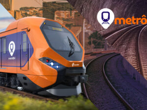 Trem laranja e azul do metrô de Belo Horizonte em uma linha férrea, com o logotipo do metrôBH ao fundo.