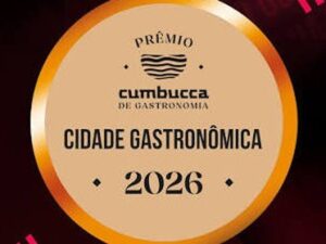 Selo dourado do Prêmio Cumbucca de Gastronomia com texto 'Cidade Gastronômica 2026', 'Premiado' lateral