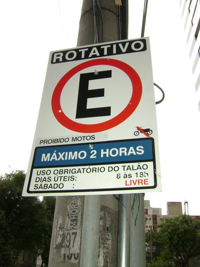 Placa de estacionamento rotativo informa limite de duas horas e uso obrigatório do talão em dias úteis, das 8h às 18h.