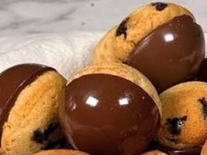 Cookies redondos com gotas de chocolate, metade coberta por chocolate escuro brilhante, sobre pano