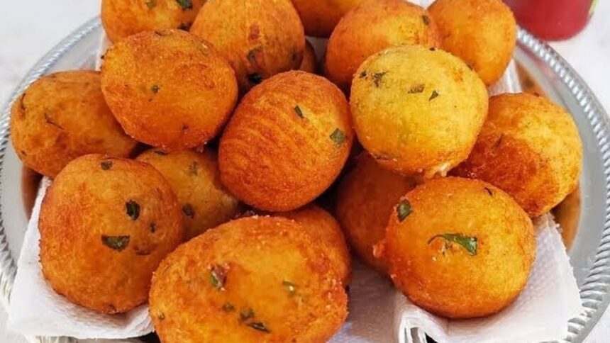 Fritters dourados e redondos com ervas, servidos em bandeja prateada com papel toalha