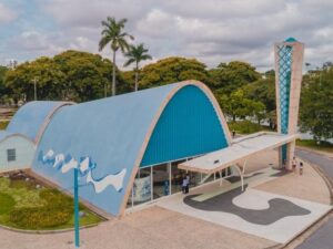 Vista aérea da Igreja da Pampulha, Belo Horizonte, com telhado azul, torre, pessoas e lago