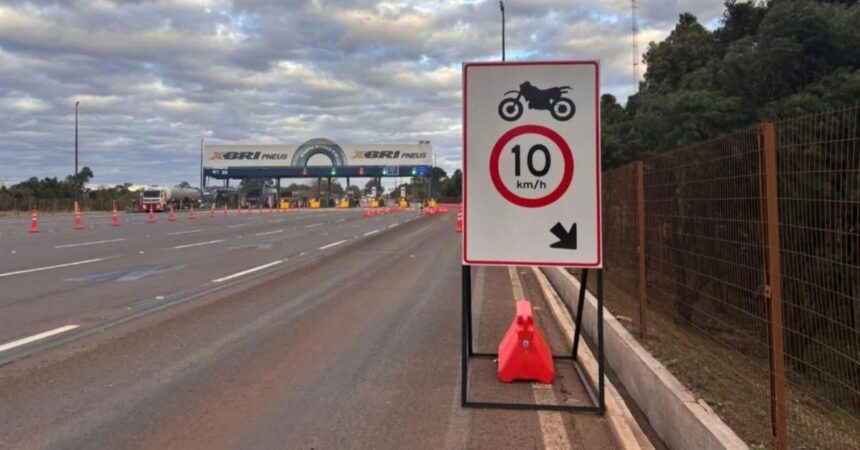Praça de pedágio da BR-040 com placa indicando passagem para motocicletas com velocidade máxima de 10 km/h.