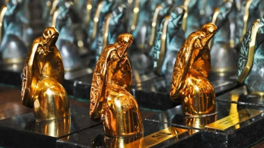Três estatuetas douradas do Prêmio Jabuti, representando figuras sentadas, com uma base mostrando '511'