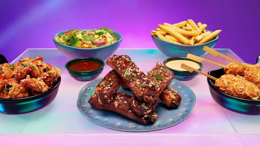 Frango frito, costelas, batatas fritas, salada e espetos coreanos em tigelas coloridas