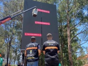 Fiscais da PBH e guindaste removem outdoor com avisos de 'Publicidade Irregular' em área arborizada