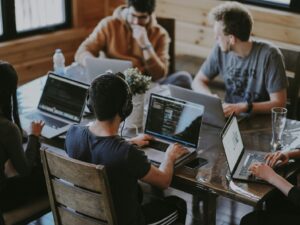 Estudantes utilizam computadores durante atividade; imagem ilustra oportunidades de estágio em Belo Horizonte.